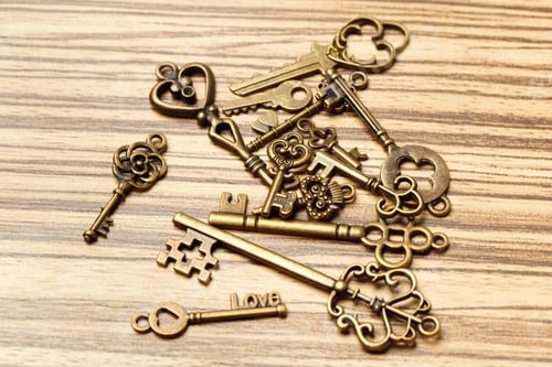 Preview: Collection of vintage keys arranged on a wooden surface focusing on unique designs and shapes