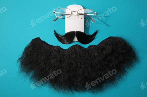 Preview: Flat lay composition with artificial moustache and glasses on light blue background