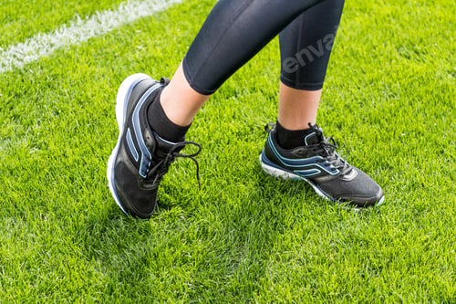 Preview: Close-up partial view of sportswoman standing on soccer stadium grass