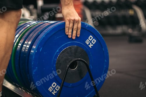 Preview: man taking a weight plate in a gym