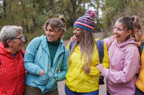 Preview: Group of happy women having fun hugging each other during hiking day in nature