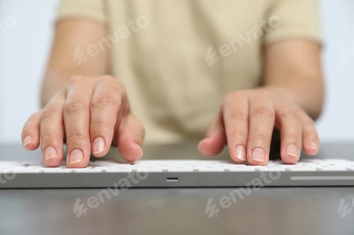 Preview: Woman typing on white wireless keyboard at grey table, closeup
