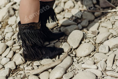 Preview: fringe boot. stylish hipster boho traveler woman wearing suede boots on river beach