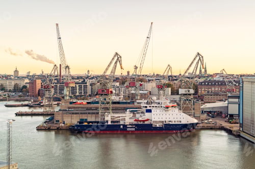 Preview: Sunrise view of a bustling shipyard at Helsinki Harbor with cranes, a large ship docked