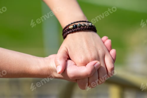 Preview: Two people holding hands, showing love and connection, close-up view