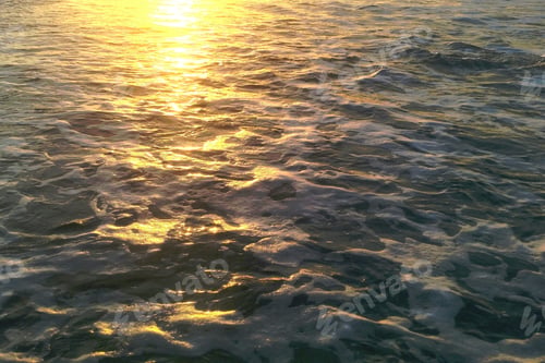 Preview: Sunlight on a turbulent sea as golden hour produces textures.
