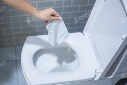 Preview: Woman hand throw paper towels in the toilet bowl. Cleaning, Lifestyle and personal hygiene concept