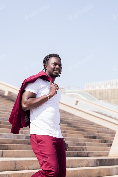 Preview: stylish black man walking down a city staircase