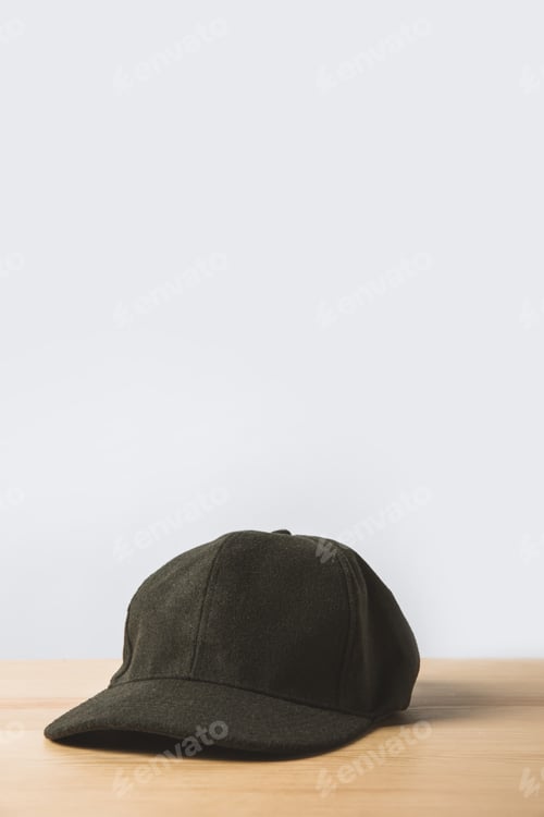 Preview: one black cap on wooden table on white