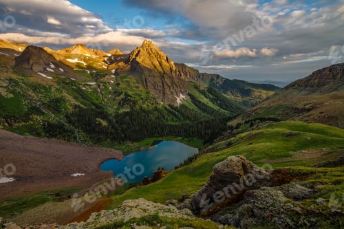 Preview: the sun is setting on the mountains and a lake below