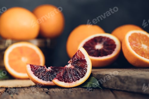 Preview: Sliced Sicilian Blood oranges fruits over old dark wooden background. Top view.