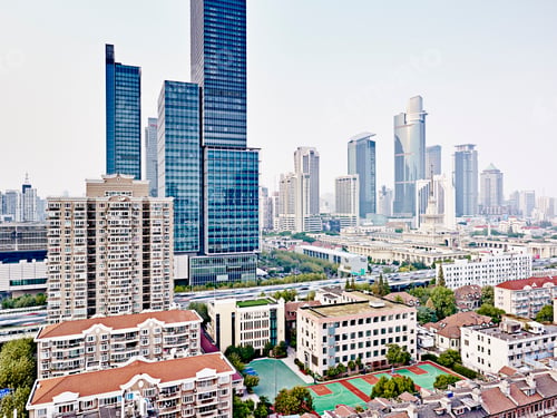 Preview: Cityscape with a blend of modern skyscrapers and traditional buildings under a hazy sky.