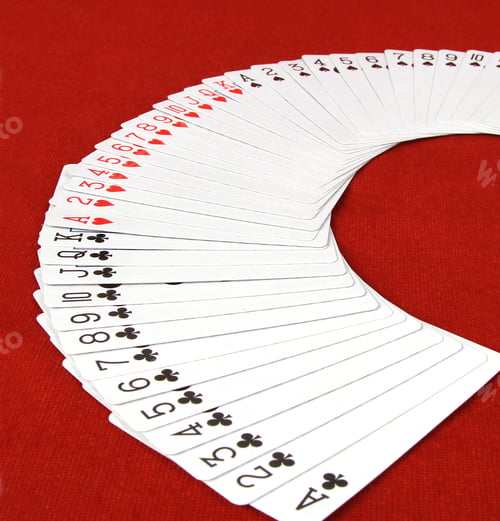 Preview: Closeup shot of a deck of playing cards fan spread isolated on a red background