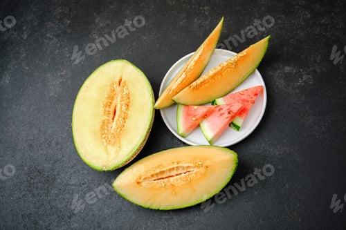 Preview: Cut cantaloupe and watermelon slices arranged on a dark surface, natural fruit presentation.