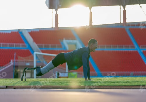 Preview: Side view of sport man athlete with a prosthesis on his leg lie down and action of push-ups