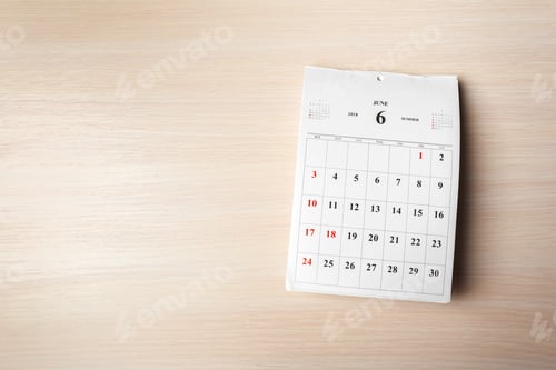 Preview: Calendar page for June shows days and dates on a wooden table surface