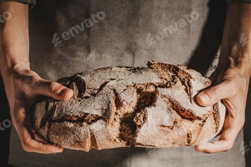 Preview: Baker or chef holding fresh made bread