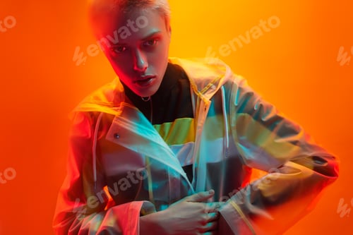 Preview: Androgynous woman wrapping in futuristic raincoat