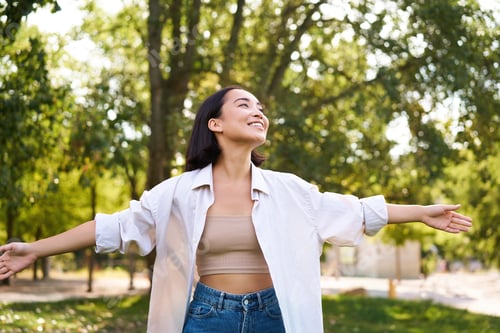 Preview: Portrait of carefree young asian woman dancing in park alone, enjoying freedom, smiling with joy