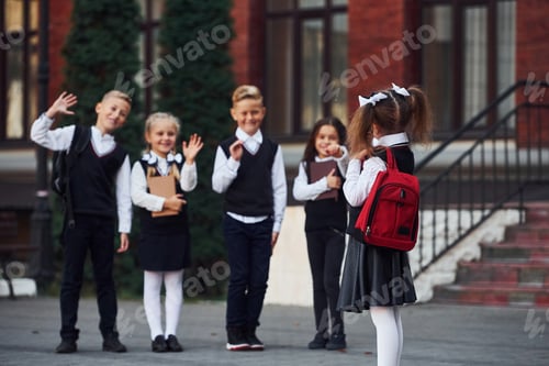 Preview: Group of kids in school uniform that is outdoors together near education building