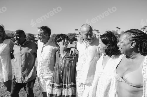 Preview: Happy senior people having fun walking on the beach wearing summer clothes