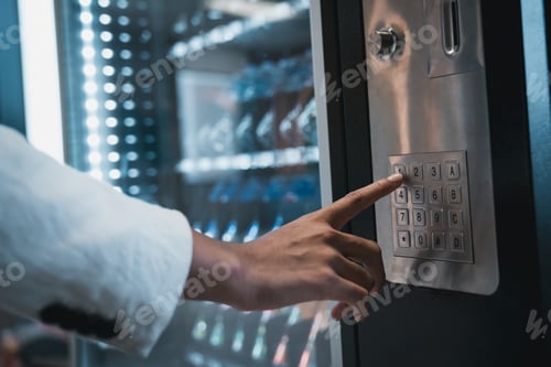 Preview: Close up hand of woman pushing button on vending machine for choosing a snack or drink.