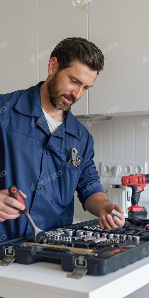 Preview: Male worker with toolbox standing on home kitchen background . High quality photo