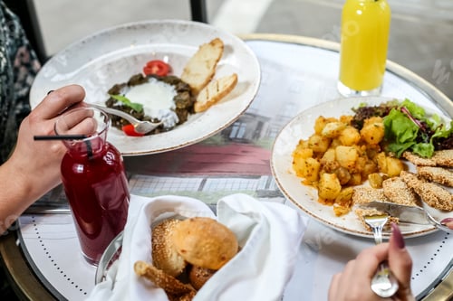 Preview: side view women eat chicken nuggets with potatoes juice and bread in a basket