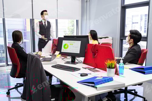 Visualização: Grupo de empresários de equipes asiáticas trabalhando em escritórios com um novo distanciamento social normal.