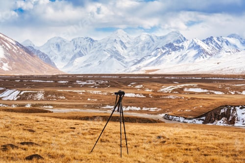 Preview: Camera tripod facing on snowy mountain range in Sary Jaz remote valley during autumn