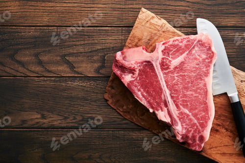 Preview: Thick Raw T-Bone Steak. Dry-aged Raw T-bone or porterhouse beef meat Steak on cutting boar with herb