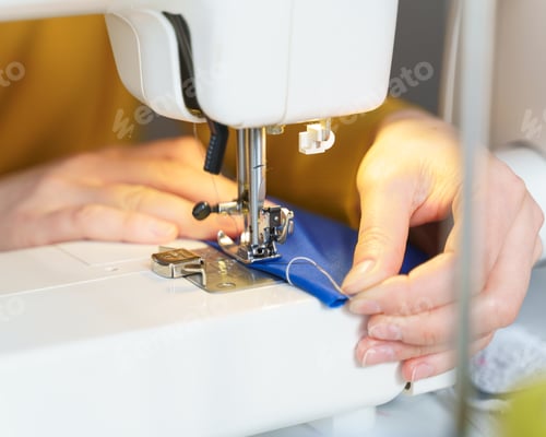 Preview: Female seamstress sewing or stitching fabric with professional machine