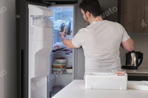 Preview: Young latin man put it in the freeze his weekly delivery of fish.
