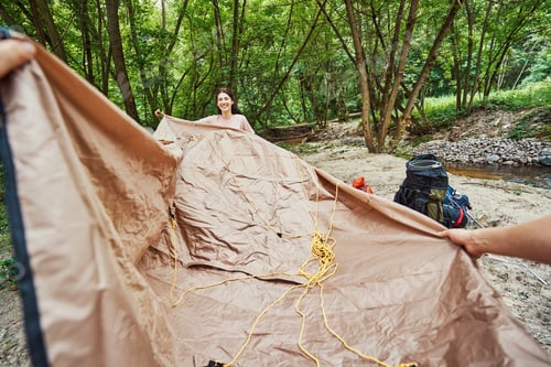 Preview: Jolly woman helping boyfriend to set camp