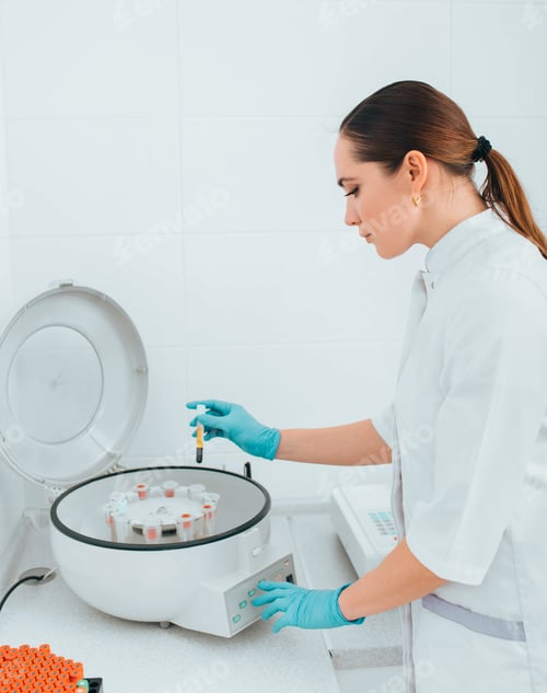 Preview: Scientist working with blood samples in vials on a centrifuge machine. Blood research