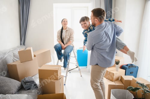 Preview: Family celebrating moving into new home with playing son