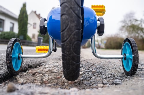 Preview: Children bike with small wheels on the sides for a safe ride on the streets of a provincial town