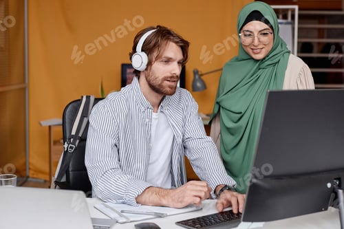 Preview: Man Discussing Project Ideas with Smiling Female Colleague in Office