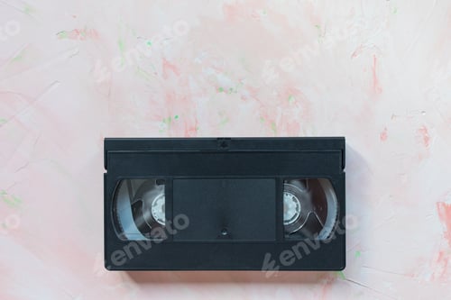 Preview: Black vintage VHS video tape on pink background