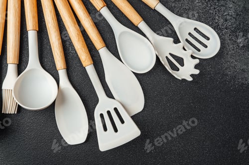 Preview: Kitchen utensils arranged on a dark surface for cooking and baking preparation
