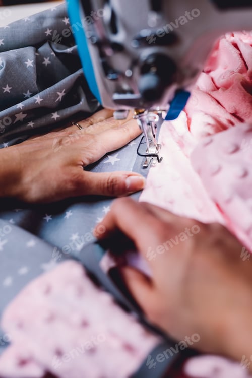 Preview: Seamstress dressmaker working with sewing machine in workshop