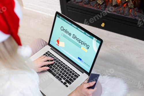 Preview: Christmas online shopping. Female buyer with laptop, copy space on screen. Woman buys presents