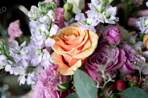Preview: Close-up of a vibrant bouquet with an orange rose and purple flowers.