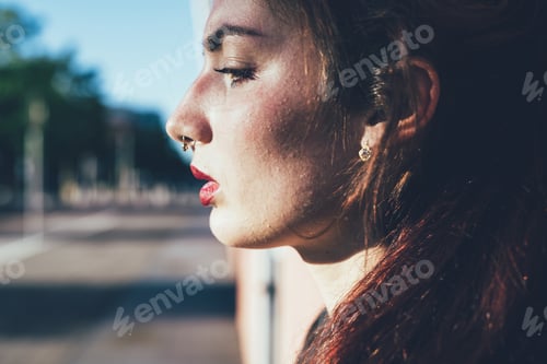 Preview: Profile portrait young woman overlooking pensive