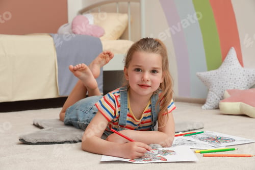 Preview: Little girl coloring antistress page on floor indoors