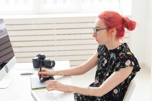 Preview: Graphic designer, animator and illustrator concept - young woman with red hair working at the laptop