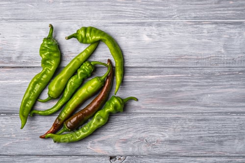 Preview: Hot spicy green chili pepper, wooden board background