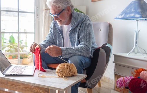 Preview: Senior man at home follow online knit tutorial to relax and enjoy resting home leisure activity