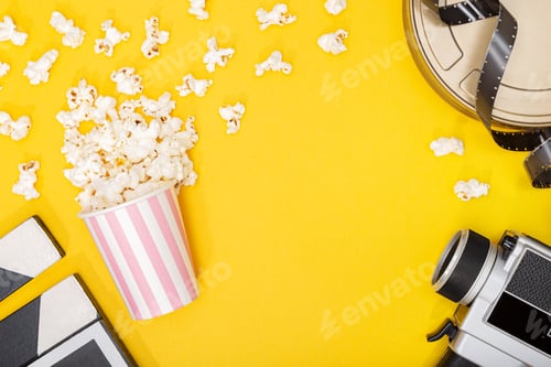Preview: Popcorn bucket, film camera, can and clapper on yellow background