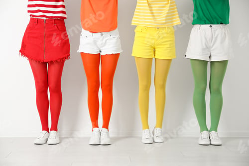 Preview: Women wearing bright tights near white wall, closeup